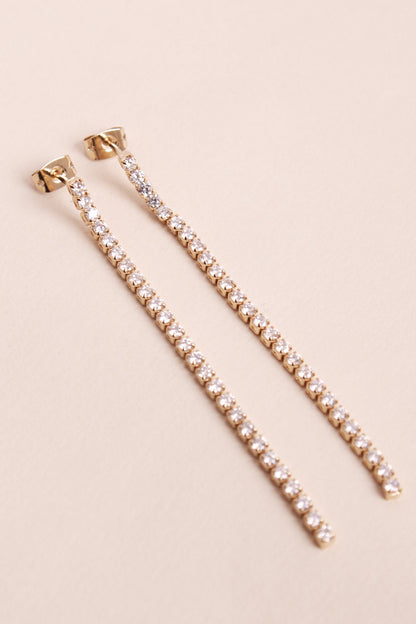 Paire de boucles d'oreilles en or et pierres de zirconium, pendante le long du cou.